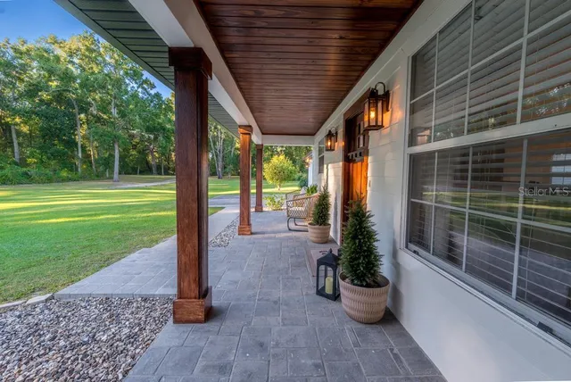 a view of a big house with a big yard and large trees