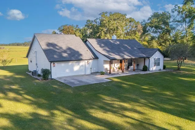 a aerial view of a house with a yard table and chairs