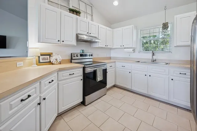 a kitchen with white cabinets and refrigerator