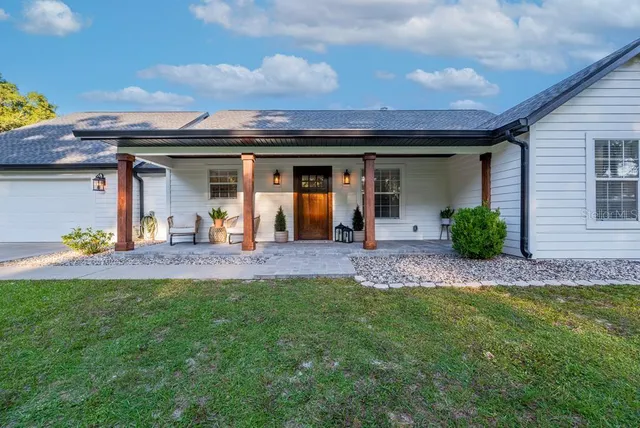 a view of a house with a porch and furniture