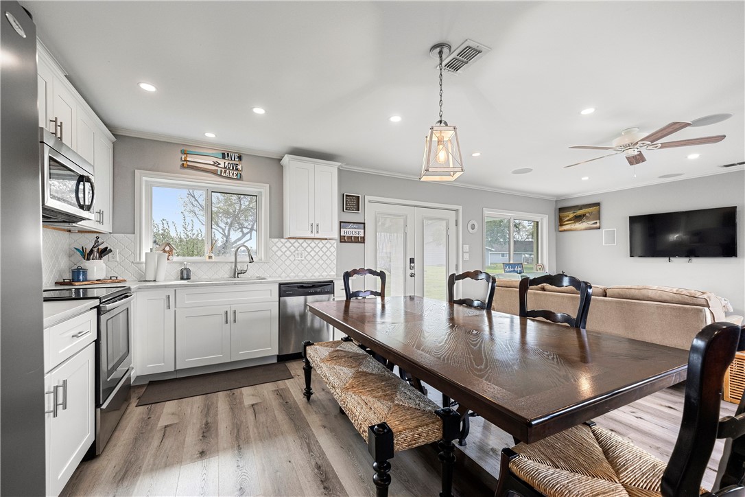 140 Zenna Drive Mathis, TX 78368 - Photo 13 of 31 a kitchen with granite countertop a stove a sink a dining table and chairs