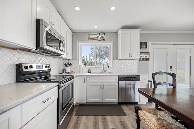 a kitchen with stainless steel appliances granite countertop a stove a sink and a microwave