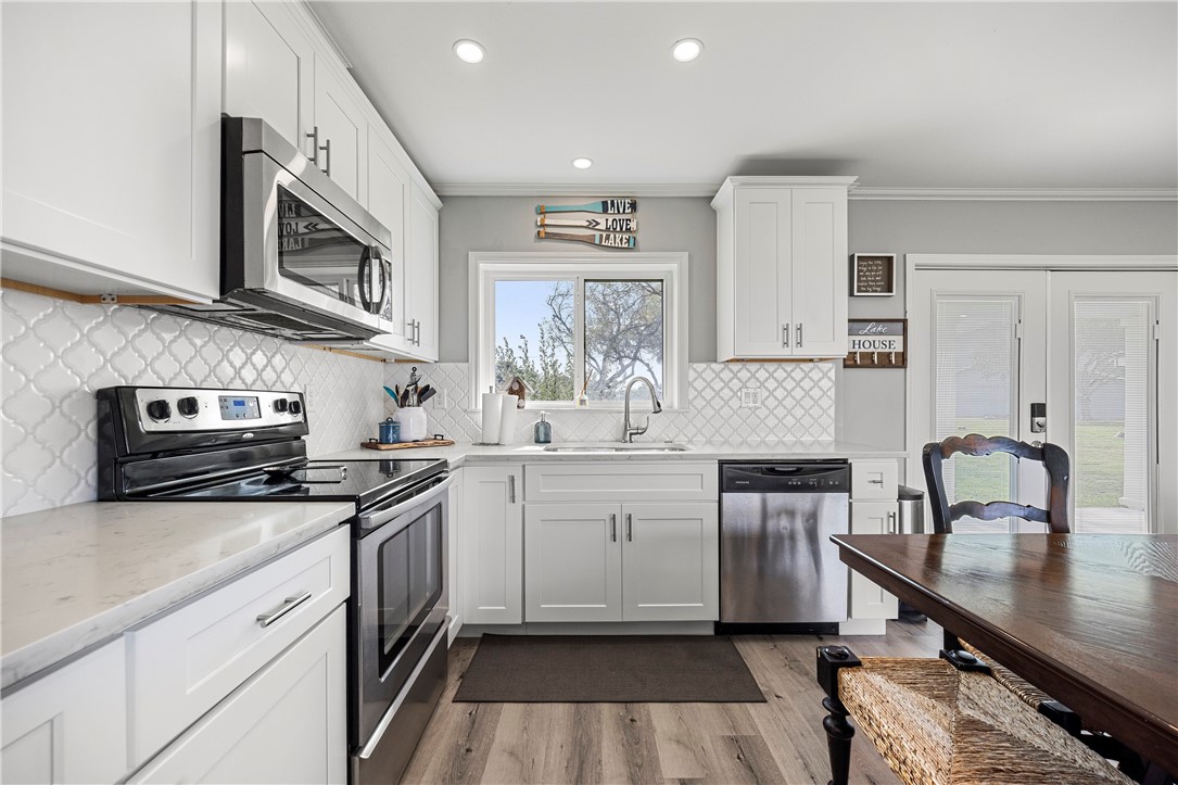 140 Zenna Drive Mathis, TX 78368 - Photo 14 of 31 a kitchen with stainless steel appliances granite countertop a stove a sink and a microwave