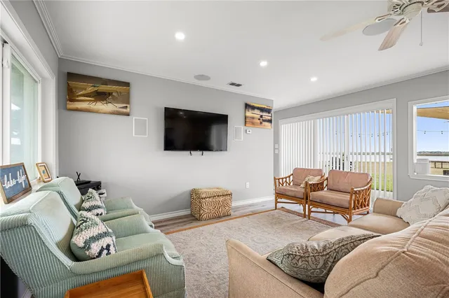 a living room with furniture a flat screen tv and a window
