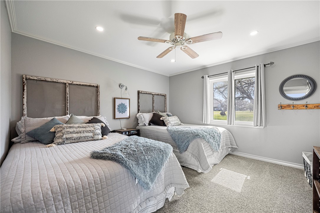 140 Zenna Drive Mathis, TX 78368 - Photo 19 of 31 a bedroom with two beds and a chandelier