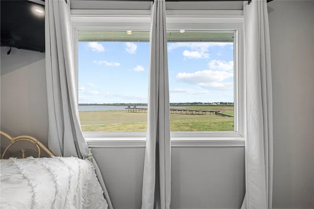 a bedroom with a bed and a large window
