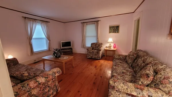 a view of a workspace with furniture and wooden floor
