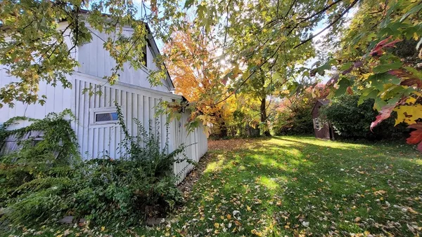 a view of a house with a yard and potted plants