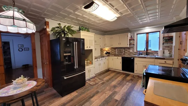 a kitchen with stainless steel appliances granite countertop a refrigerator a stove and a wooden floors