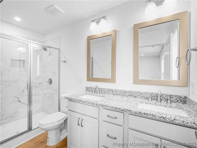 a bathroom with a granite countertop sink toilet and shower