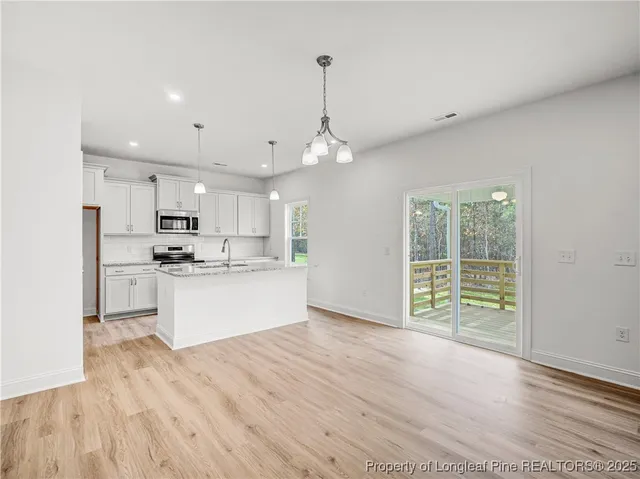 a large kitchen with kitchen island a sink stainless steel appliances and cabinets