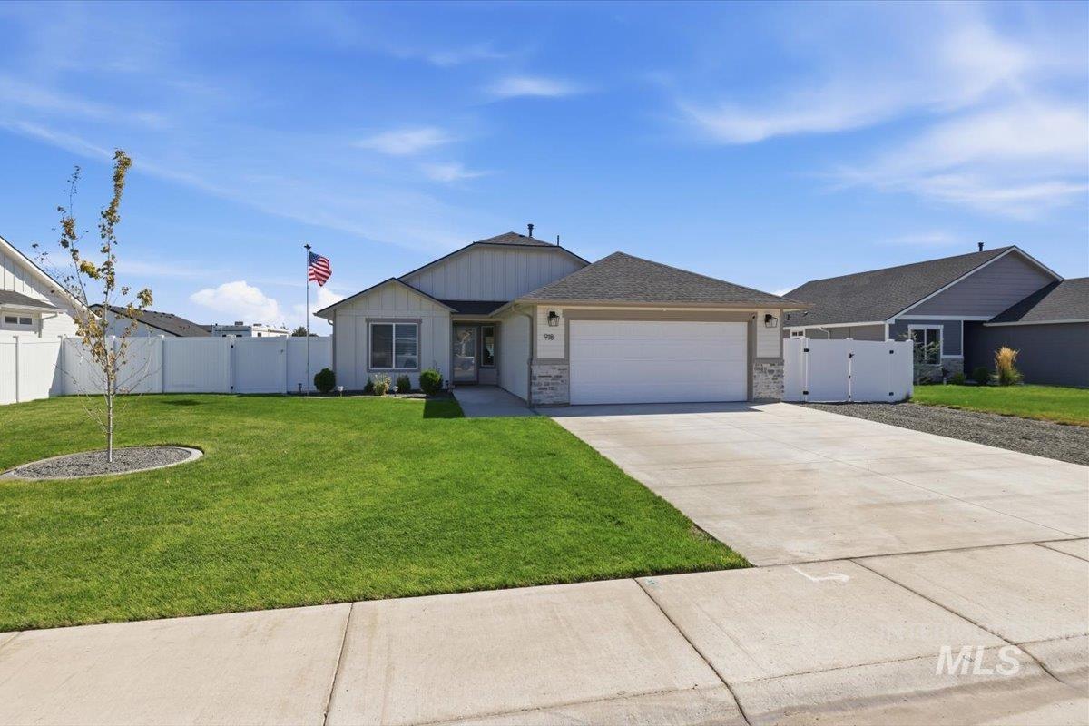 918 Sierra Street Vale, OR 97918 - Photo 4 of 42 Single-story residence featuring a two-car garage, stone and siding exterior, concrete driveway, and a fenced yard