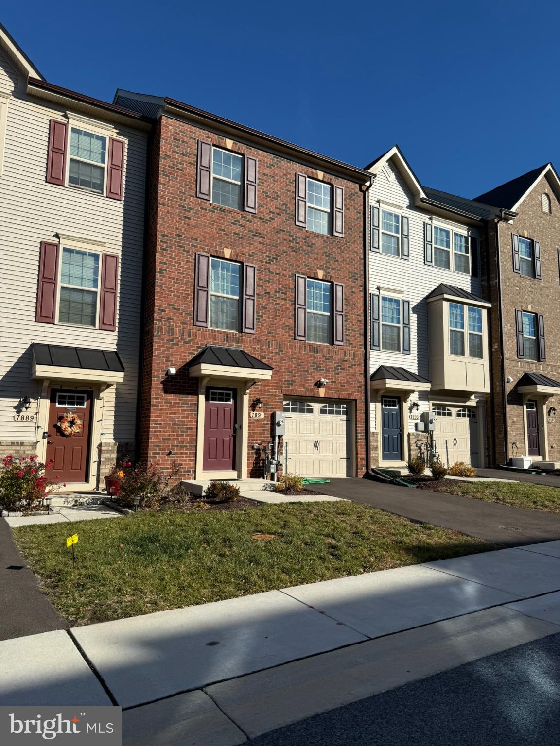 a front view of residential houses with yard and green space
