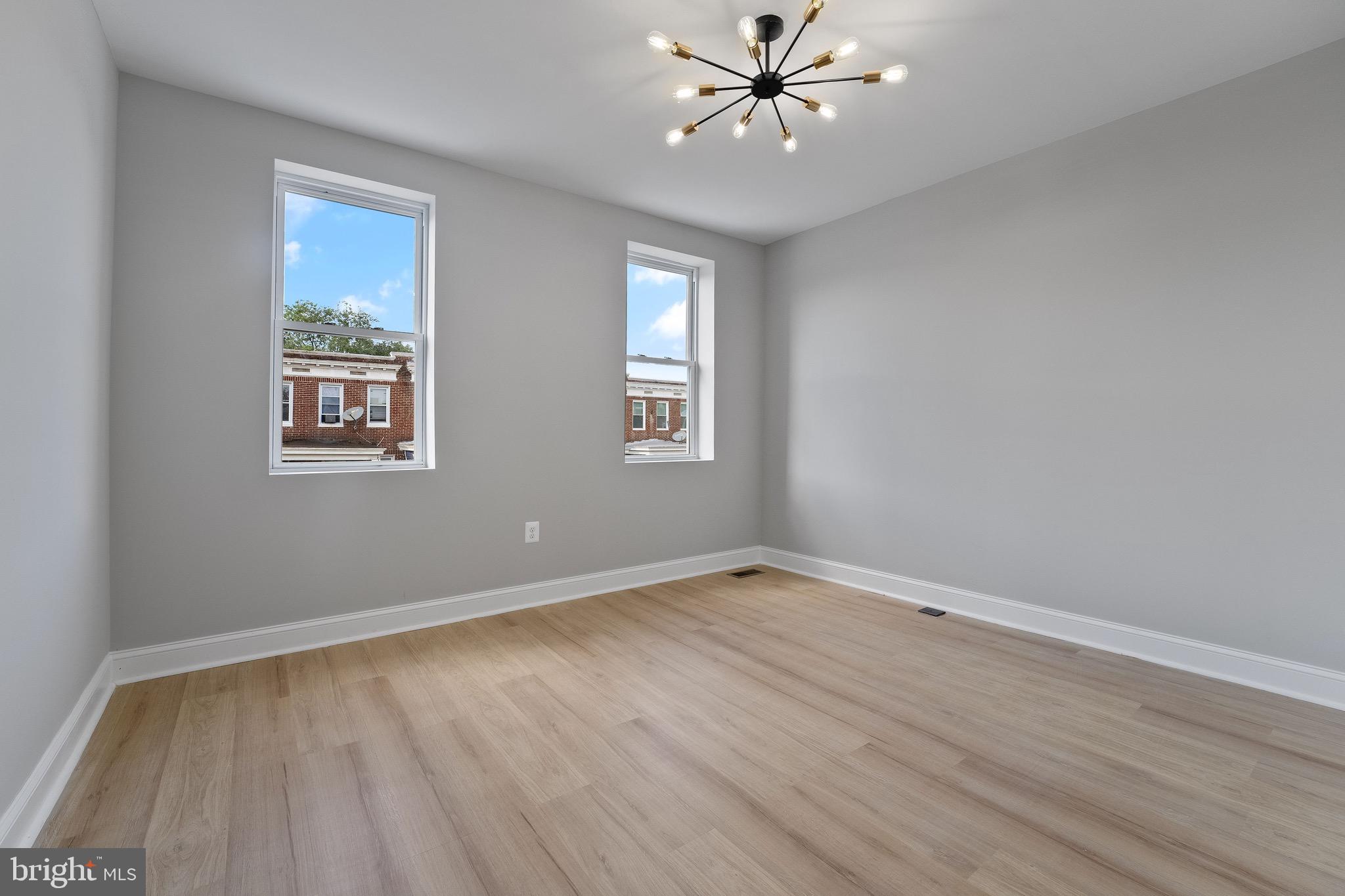 655 Dumbarton Avenue Baltimore, MD 21218 - Photo 16 of 28 a view of an empty room with a window and wooden floor