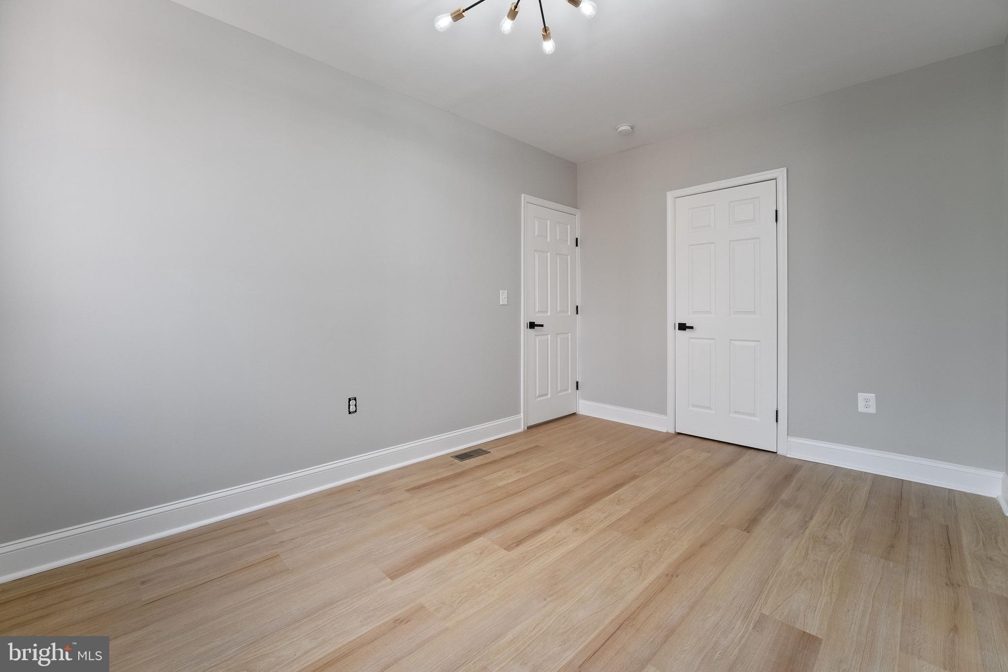 655 Dumbarton Avenue Baltimore, MD 21218 - Photo 19 of 28 a view of an empty room with wooden floor