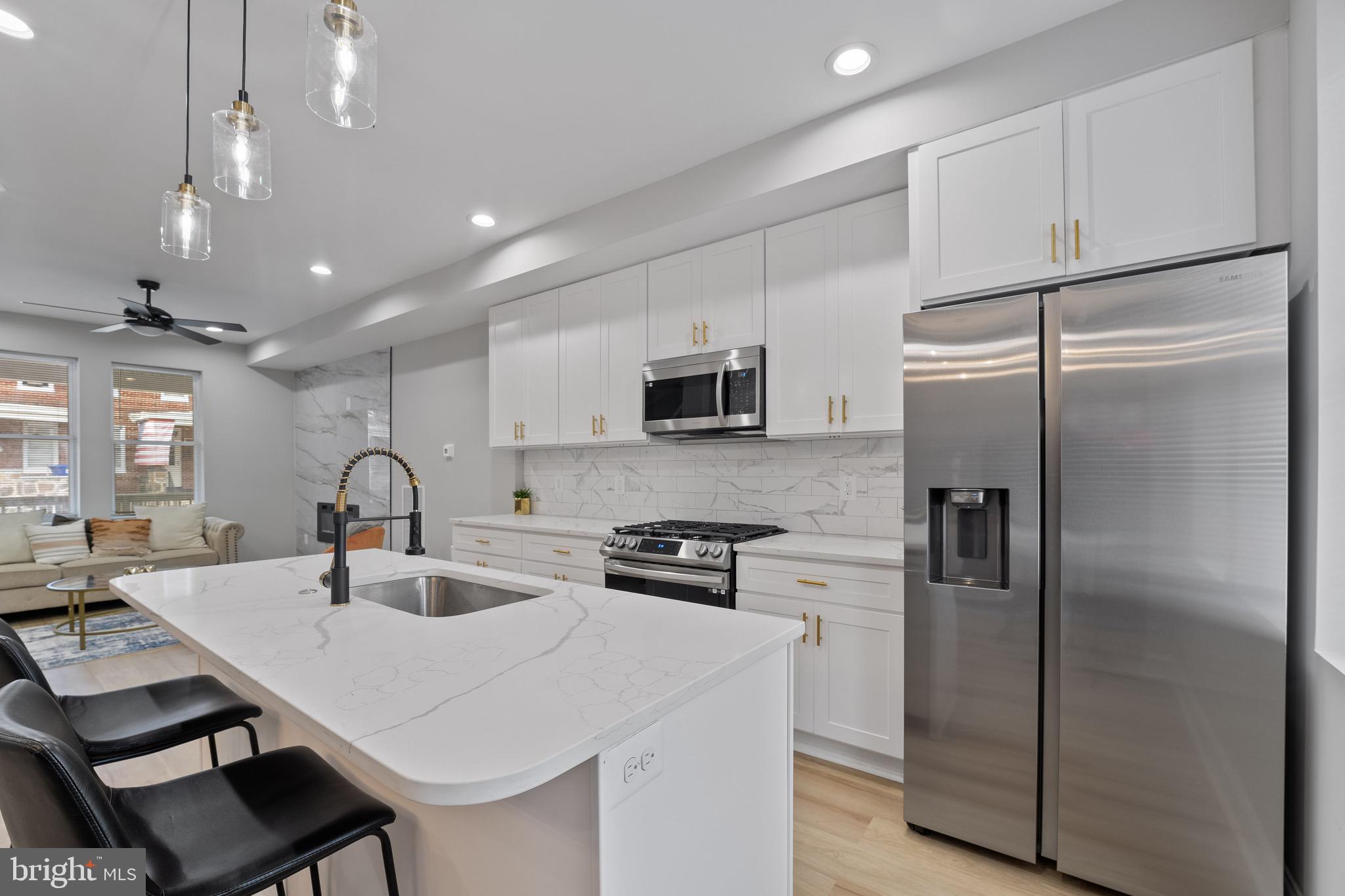 655 Dumbarton Avenue Baltimore, MD 21218 - Photo 5 of 28 a kitchen with stainless steel appliances a refrigerator sink and cabinets