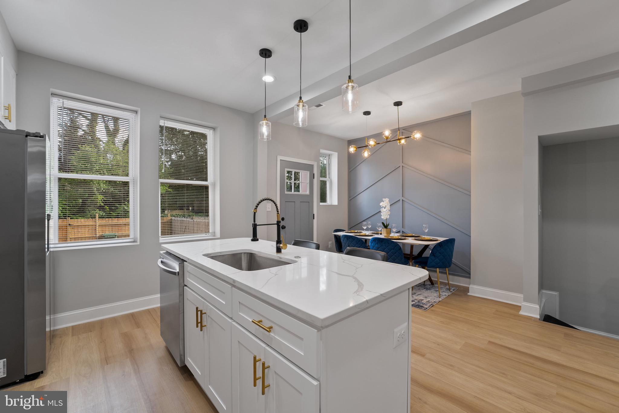 655 Dumbarton Avenue Baltimore, MD 21218 - Photo 8 of 28 a kitchen that has a sink a stove and a wooden floor