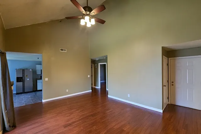 a view of empty room with wooden floor