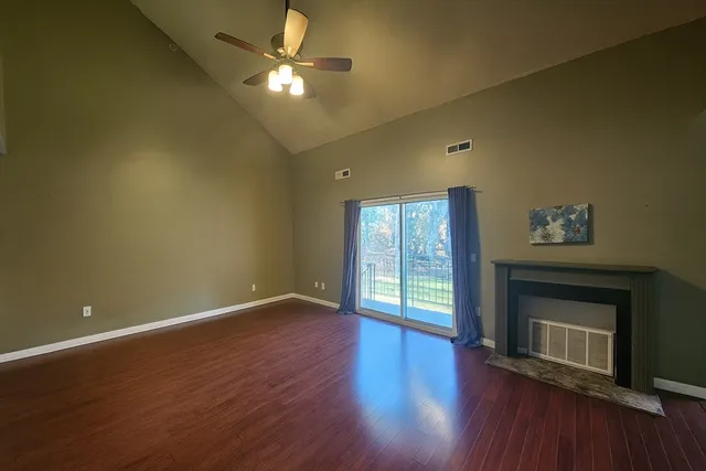 a view of an empty room with a fireplace and a window