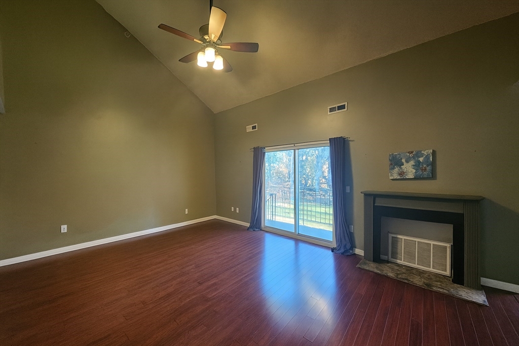 124 Tennis Plaza Road, Unit 22 Dracut, MA 01826 - Photo 3 of 9 a view of an empty room with a fireplace and a window