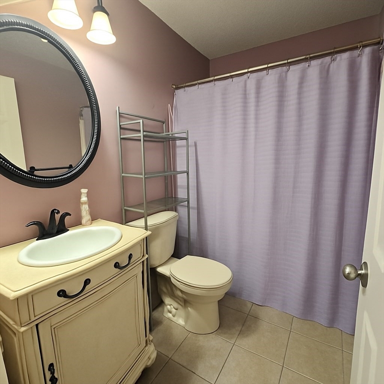 124 Tennis Plaza Road, Unit 22 Dracut, MA 01826 - Photo 8 of 9 a bathroom with a toilet a sink and a mirror