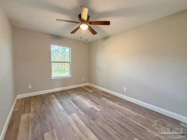 wooden floor in an empty room with a window
