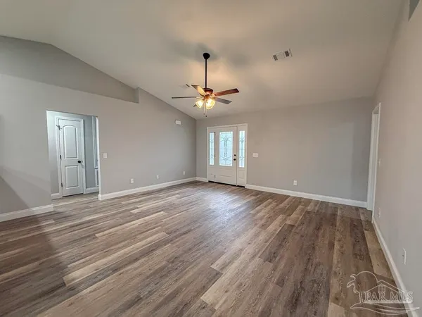 wooden floor in an empty room with a window
