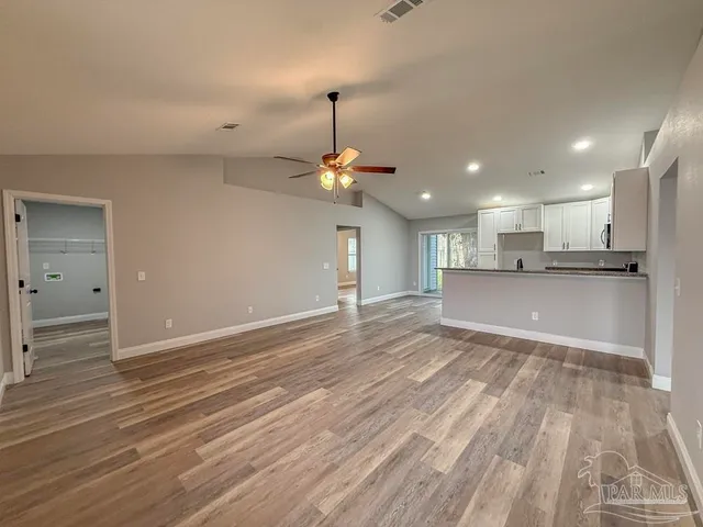 a view of a kitchen with a refrigerator a ceiling fan and wooden floor