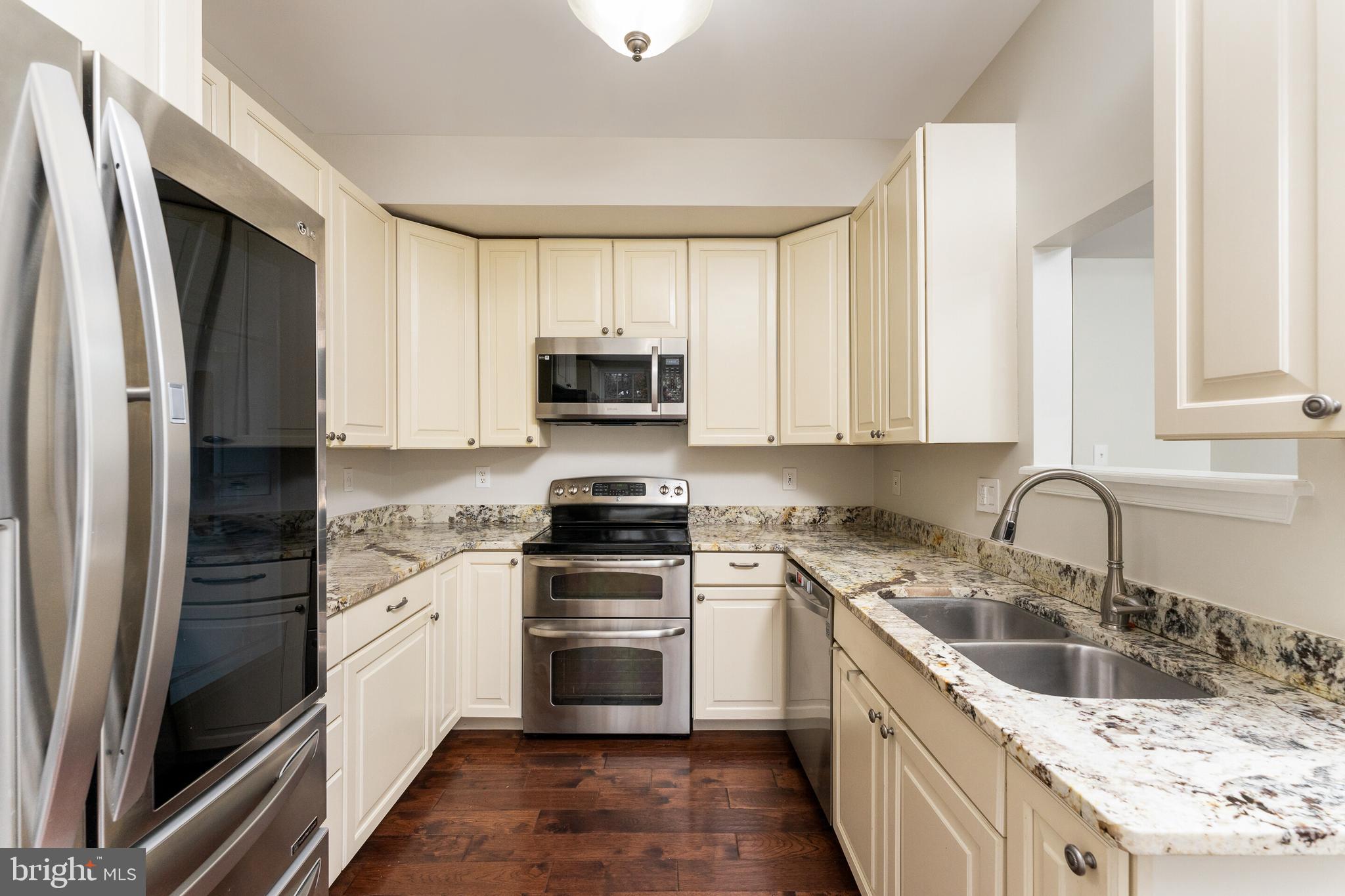 5311 Yellow Turtle Place Woodbridge, VA 22193 - Photo 16 of 36 a kitchen with stainless steel appliances granite countertop a sink stove and refrigerator