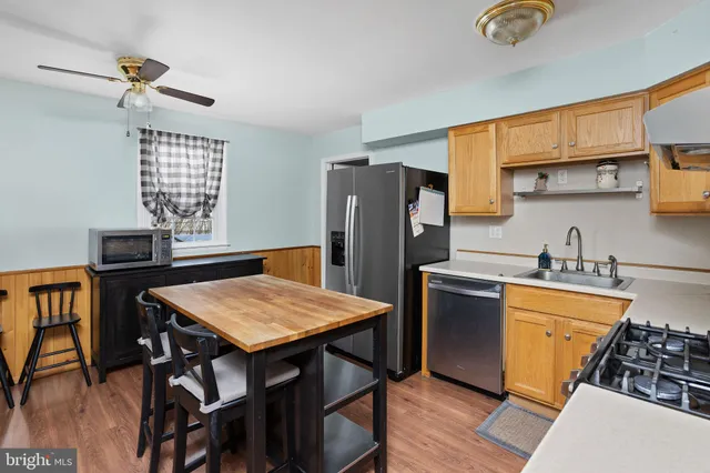 a kitchen with stainless steel appliances granite countertop a stove refrigerator sink and cabinets