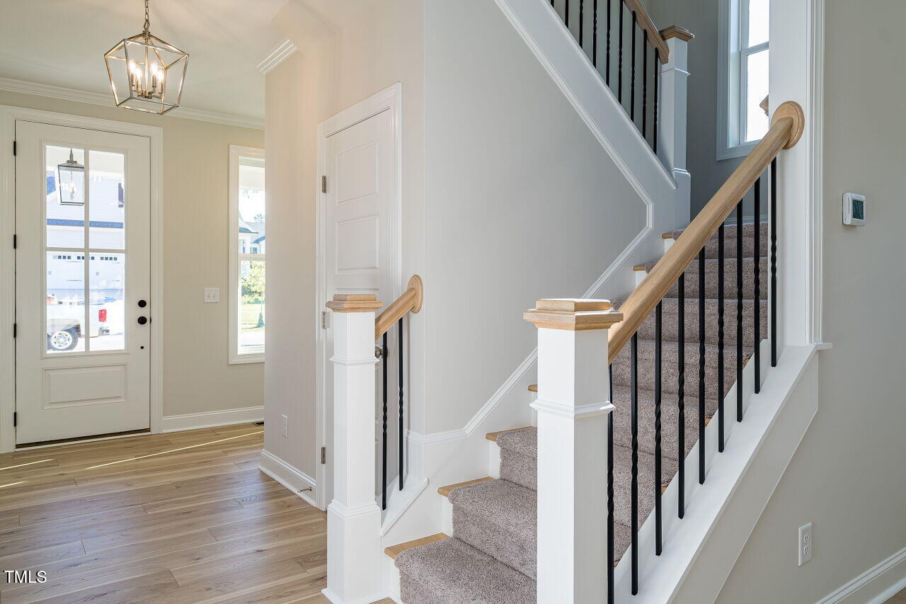 6045 Scalybark Road Durham, NC 27712 - Photo 4 of 30 a view of staircase with wooden floor and pendant lights