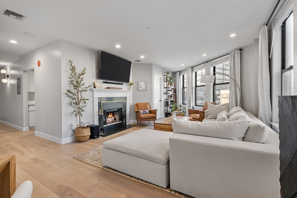 75 Clarendon Street, Unit 201 Boston, MA 02116 - Photo 1 of 15 a living room with furniture a flat screen tv and a fireplace