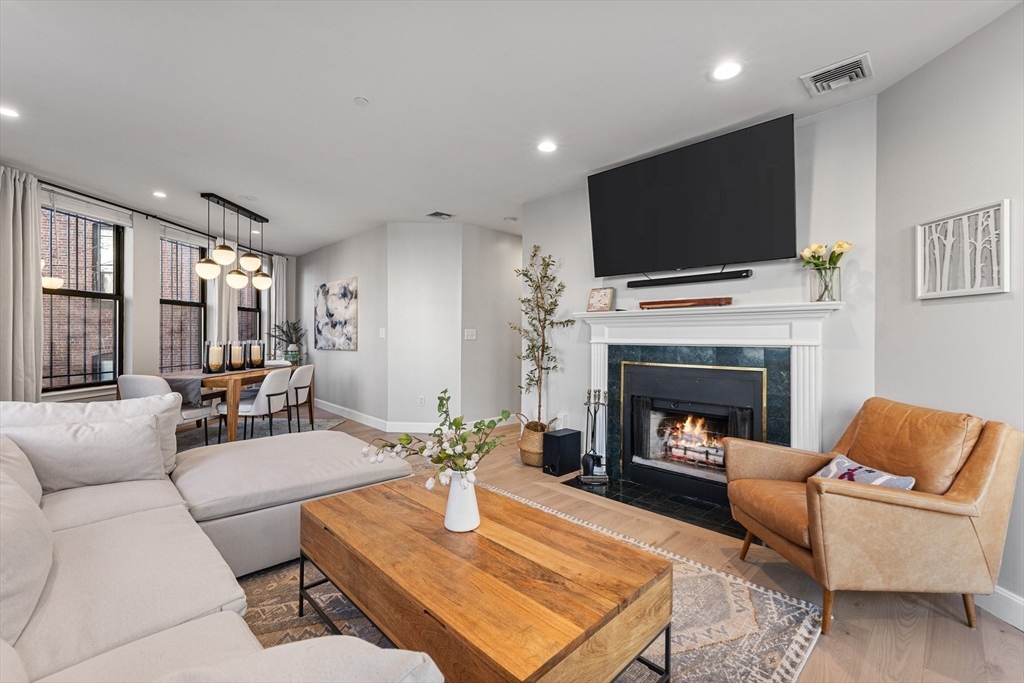75 Clarendon Street, Unit 201 Boston, MA 02116 - Photo 2 of 15 a living room with furniture a flat screen tv and a fireplace