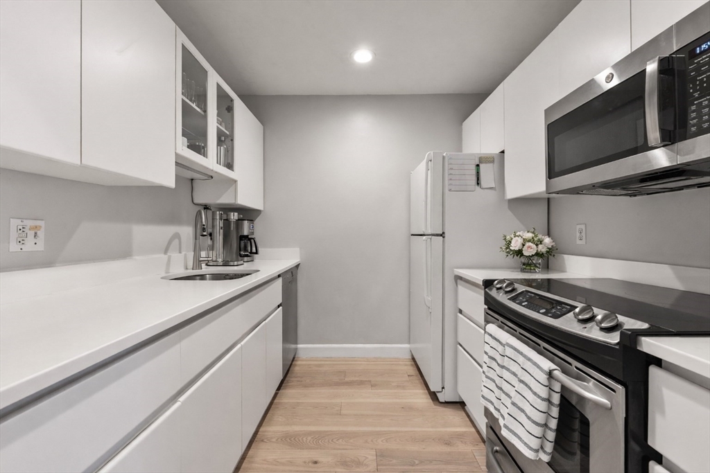 75 Clarendon Street, Unit 201 Boston, MA 02116 - Photo 4 of 12 a kitchen with stainless steel appliances a sink dishwasher a stove and a microwave oven with cabinets