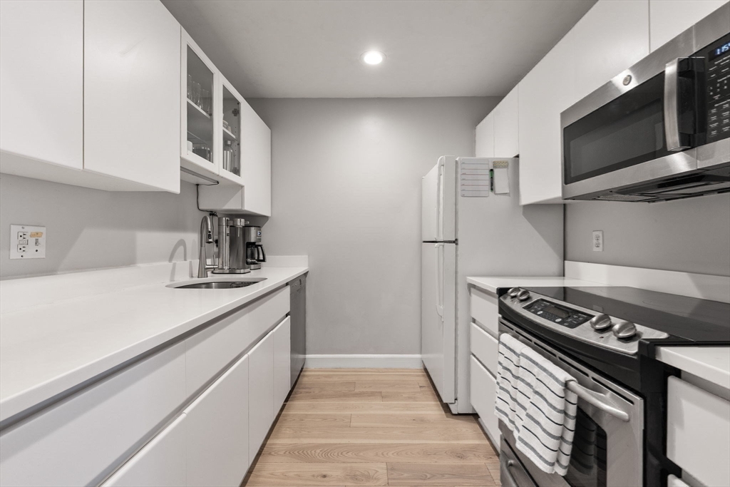 75 Clarendon Street, Unit 201 Boston, MA 02116 - Photo 5 of 15 a kitchen with stainless steel appliances a sink dishwasher a stove and a microwave oven with cabinets