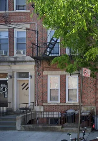 a front view of a house with a tree