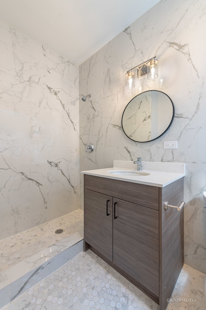 4152 South Prairie Avenue, Unit 1 Chicago, IL 60653 - Photo 21 of 27 a bathroom with a sink mirror and vanity