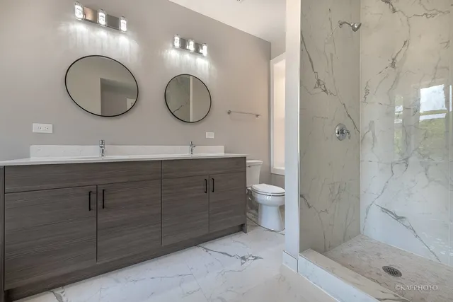 a bathroom with a double vanity sink mirror and toilet