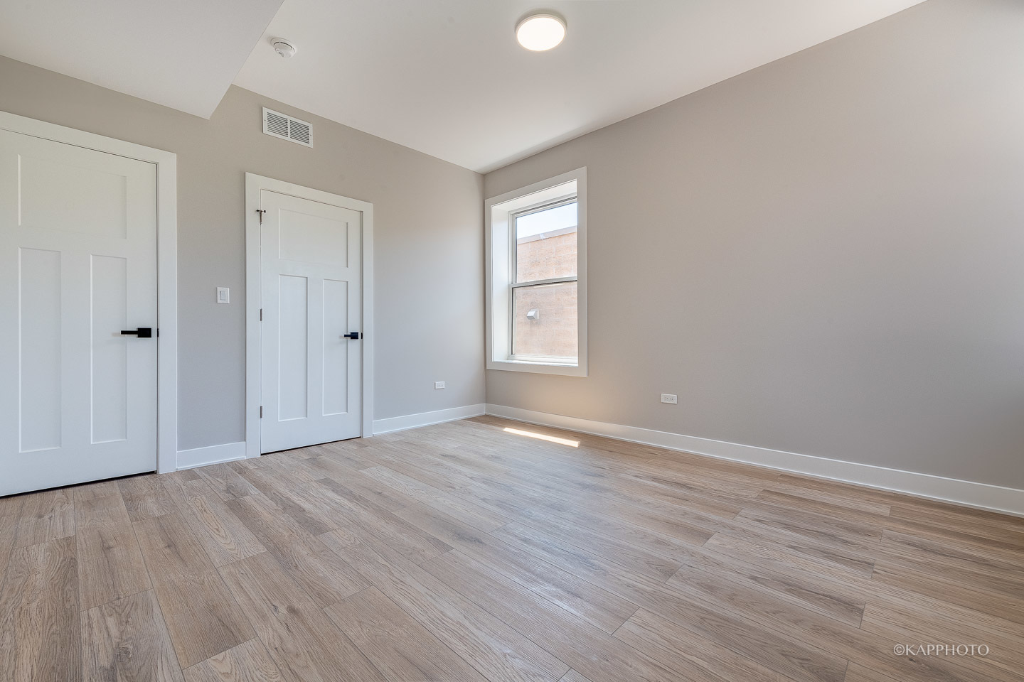 4152 South Prairie Avenue, Unit 1 Chicago, IL 60653 - Photo 4 of 27 a view of an empty room with wooden floor and a window