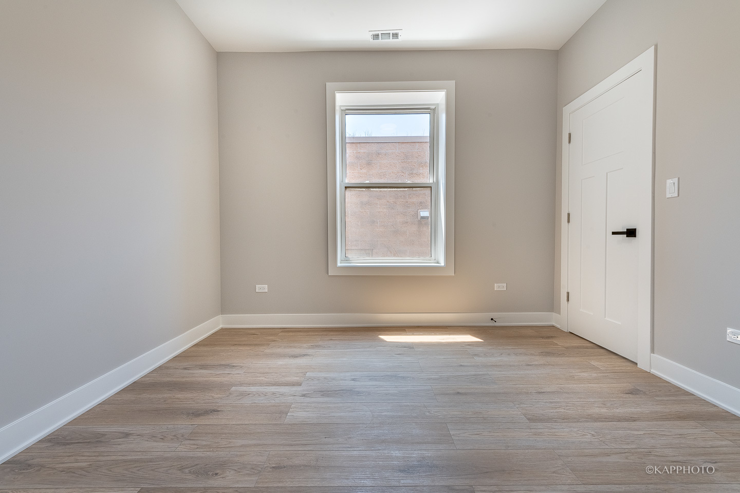 4152 South Prairie Avenue, Unit 1 Chicago, IL 60653 - Photo 5 of 27 an empty room with wooden floor and windows