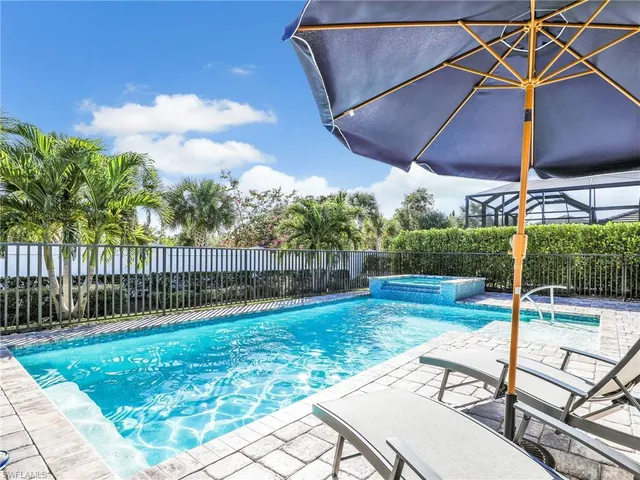 a bedroom with a large bed and a chandelier fan