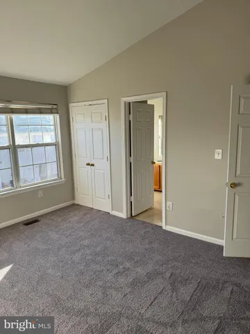 an empty room with windows and closet