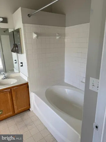 a bathroom with a tub sink and mirror