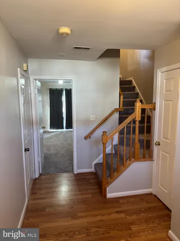 a view of entryway and hall with wooden floor