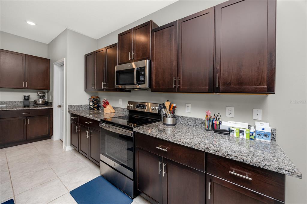 16654 Carlton Pond Street Wimauma, FL 33598 - Photo 11 of 48 a kitchen with granite countertop cabinets stainless steel appliances and a sink