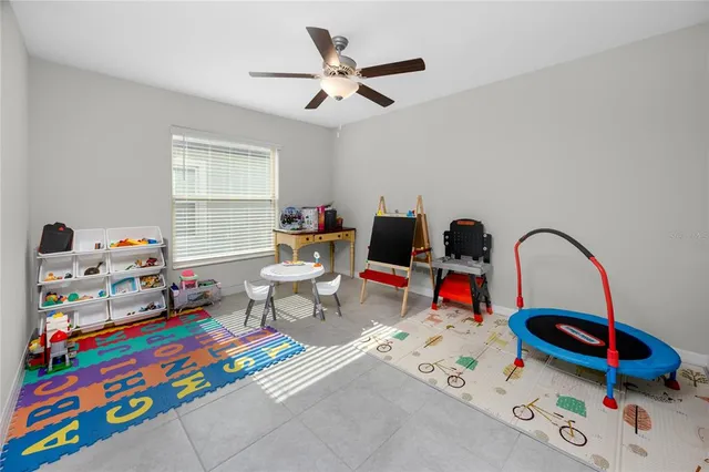 a living room with furniture and a baby crib
