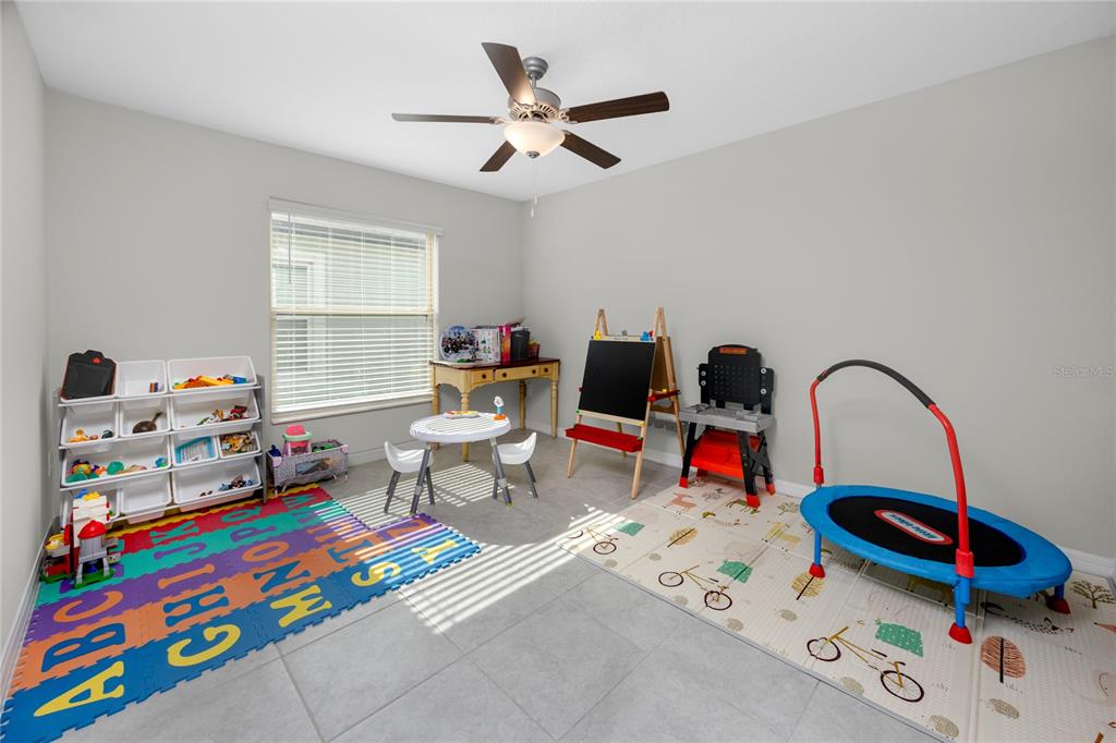 16654 Carlton Pond Street Wimauma, FL 33598 - Photo 16 of 48 a living room with furniture and a baby crib