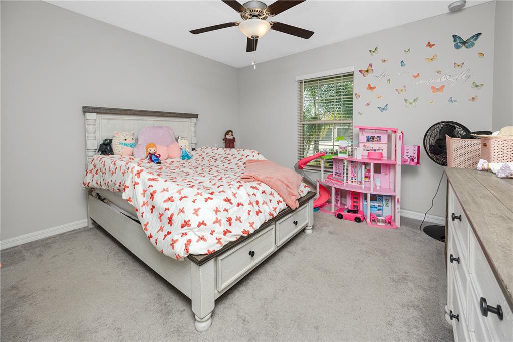 16654 Carlton Pond Street Wimauma, FL 33598 - Photo 18 of 48 a bed room with a bed and a baby bed