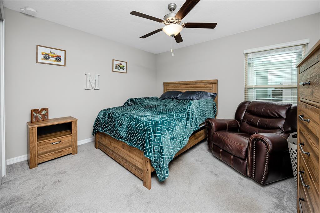 16654 Carlton Pond Street Wimauma, FL 33598 - Photo 22 of 48 a bedroom with a bed couch and window