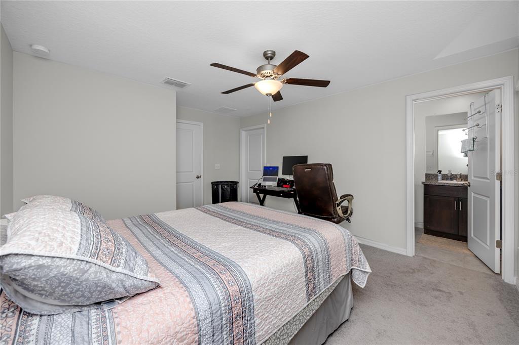 16654 Carlton Pond Street Wimauma, FL 33598 - Photo 25 of 48 a bedroom with a bed and a chandelier